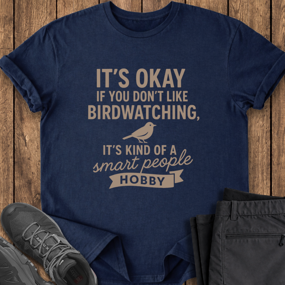 Navy blue t-shirt with humorous text design on a wooden surface with shoes and pants.