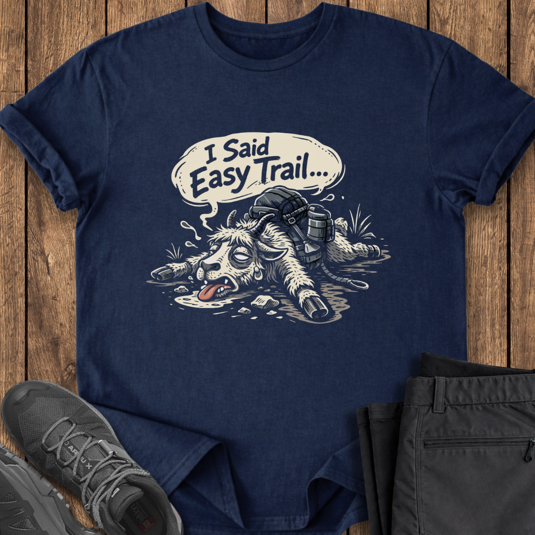 Navy blue t-shirt with graphic design and text 'I Said Easy Trail' on a wooden surface with shoes and pants. funny goat slow hiking t shirt