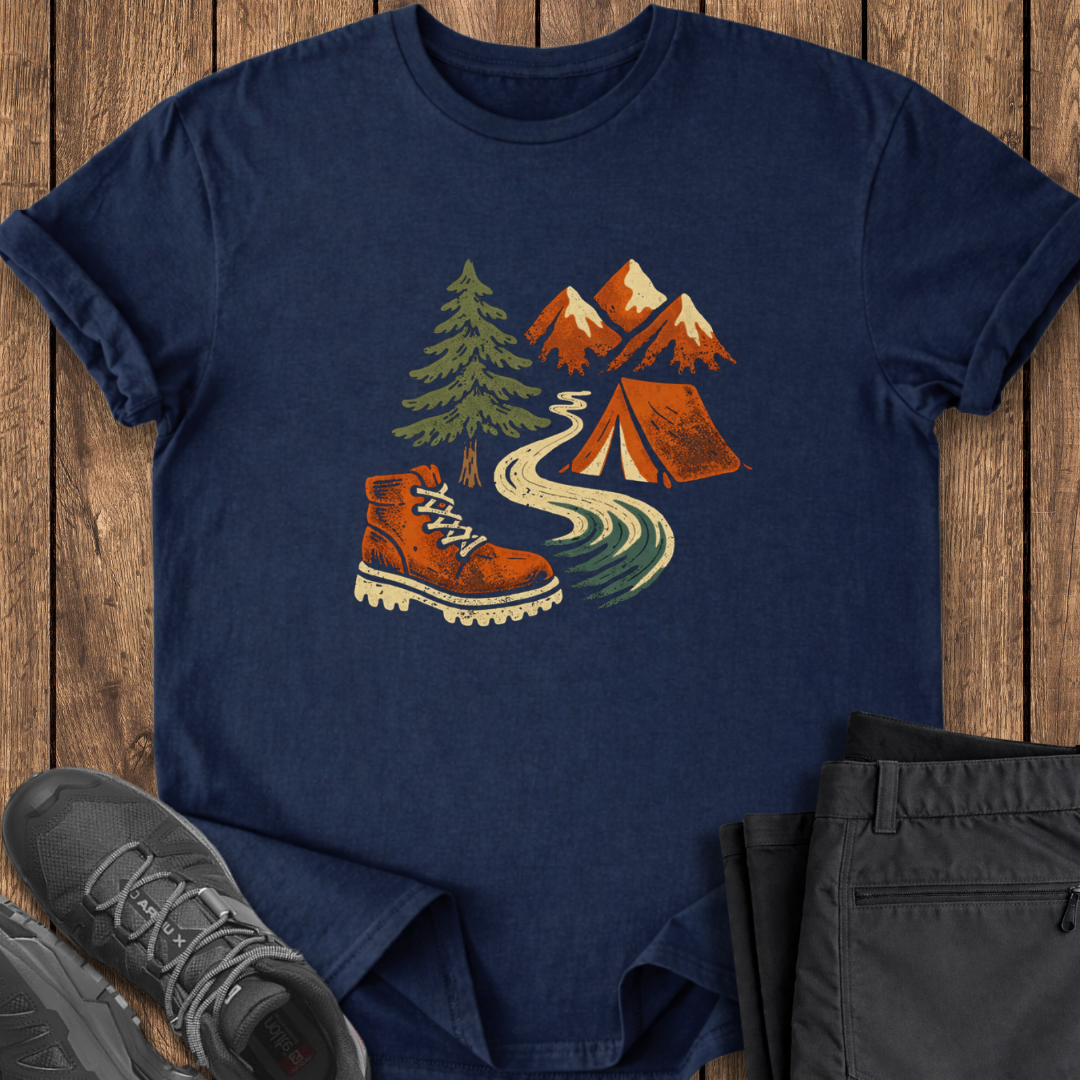 Navy blue t-shirt with outdoor design featuring a boot, tent, and mountains on a wooden surface.