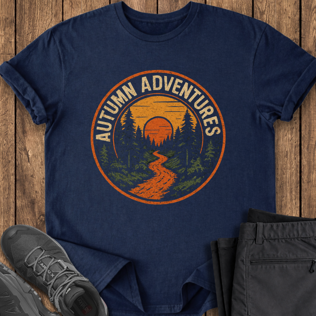 Navy blue t-shirt with 'Autumn Adventures' graphic on a wooden surface with shoes and pants. hiking outdoor t shirt