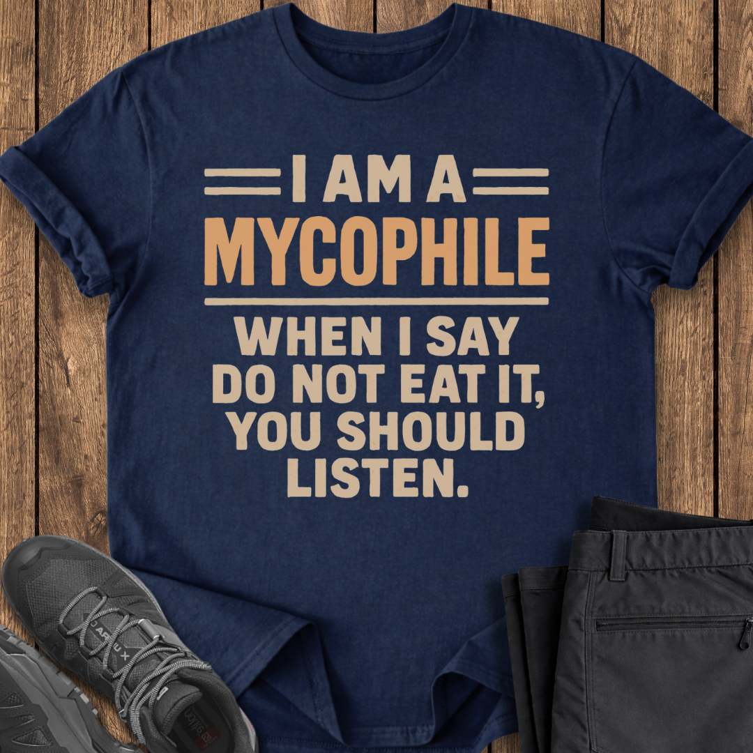 Navy blue t-shirt with humorous text design on a wooden surface with shoes and pants.