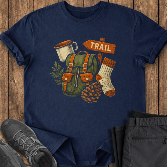 Navy blue t-shirt with outdoor-themed design on a wooden surface with shoes and pants.