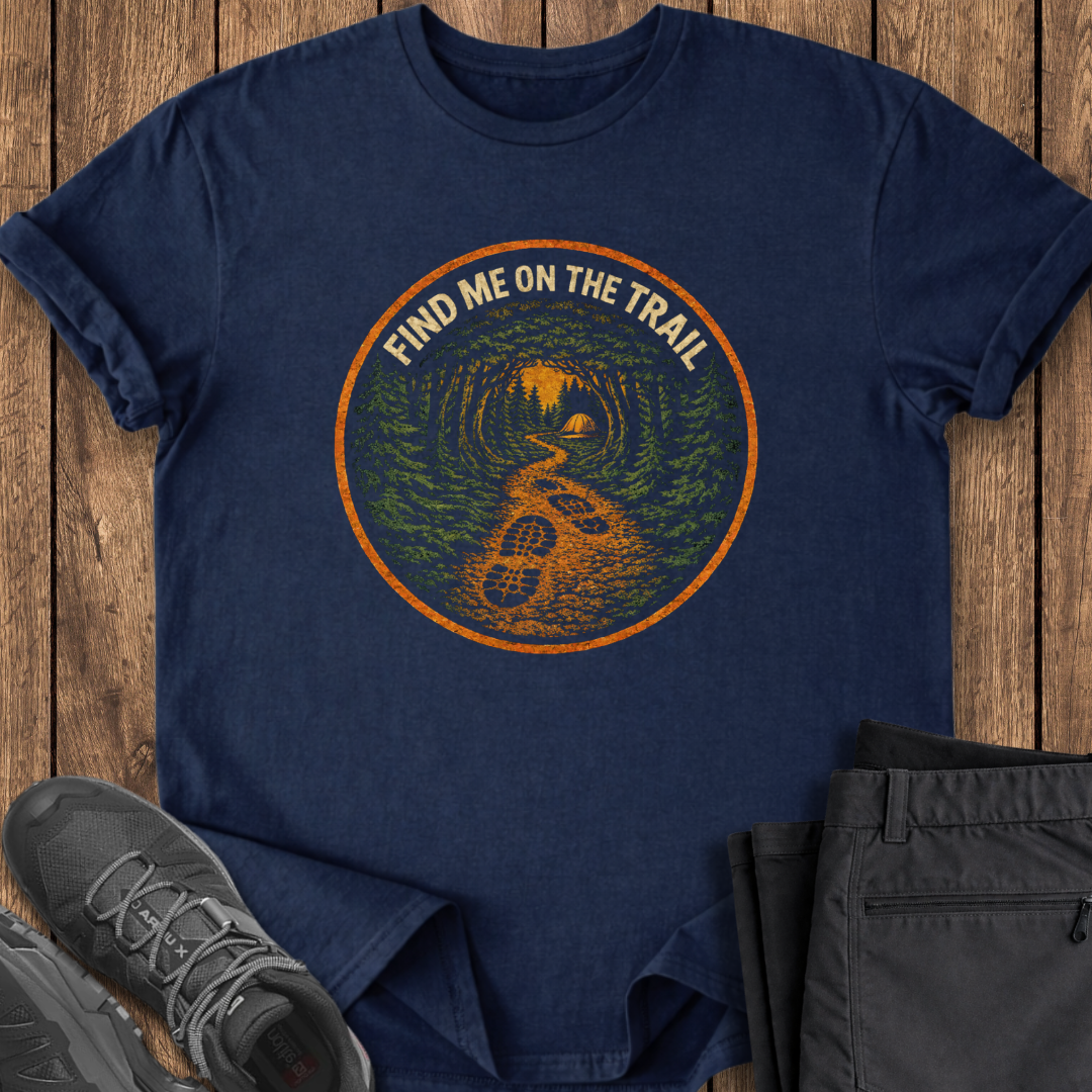 Navy blue t-shirt with 'Find Me on the Trail' graphic on a wooden surface with shoes and pants. hiking t shirt