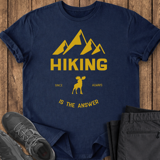 Navy blue t-shirt with yellow mountain and moose graphic on a wooden surface with shoes and pants. funny mental health t shirts