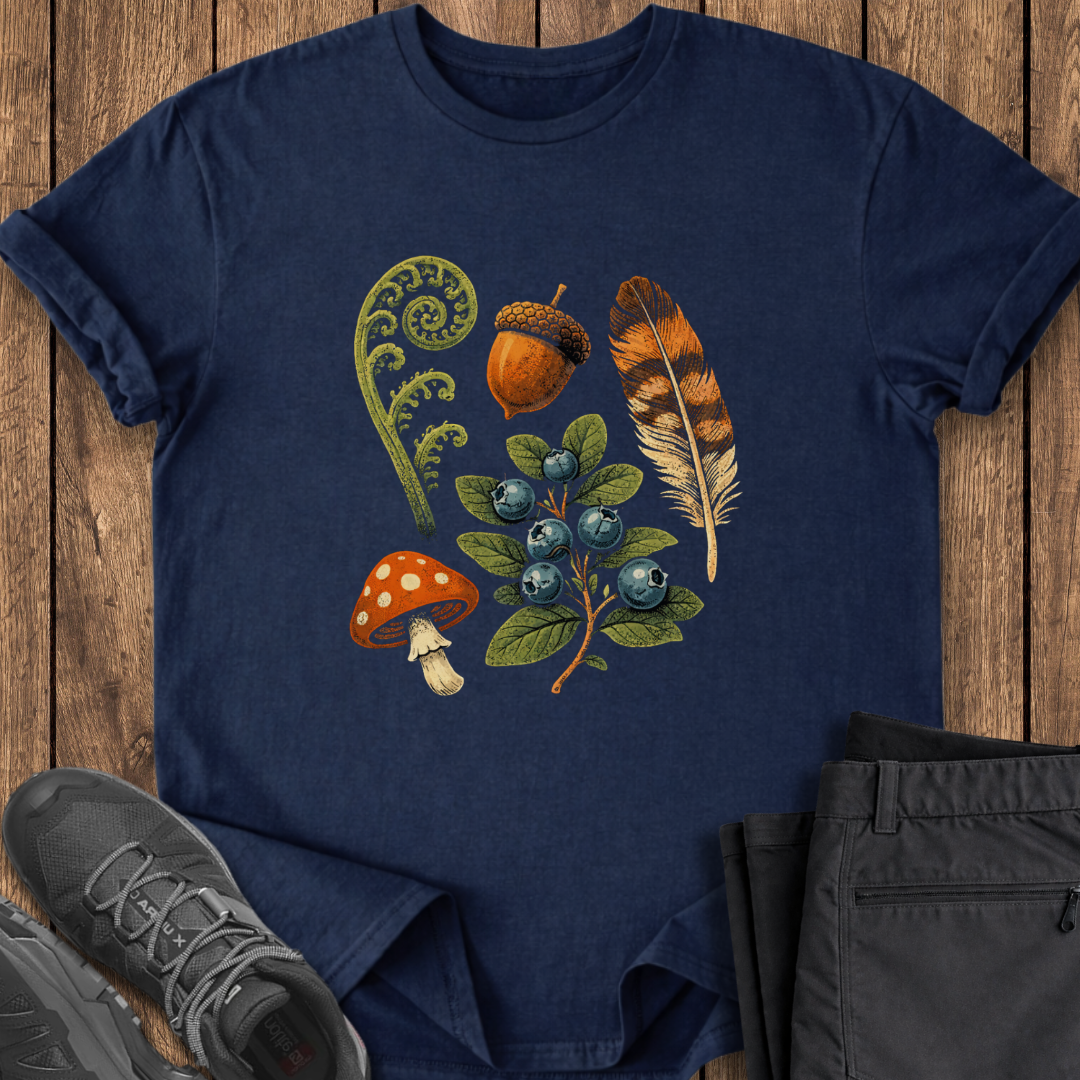 Navy blue t-shirt with nature-themed design on a wooden surface with shoes and pants.
