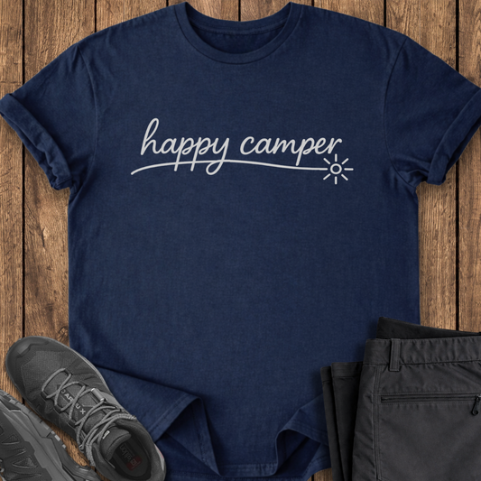 Navy blue t-shirt with 'happy camper' text on a wooden surface with shoes and pants.