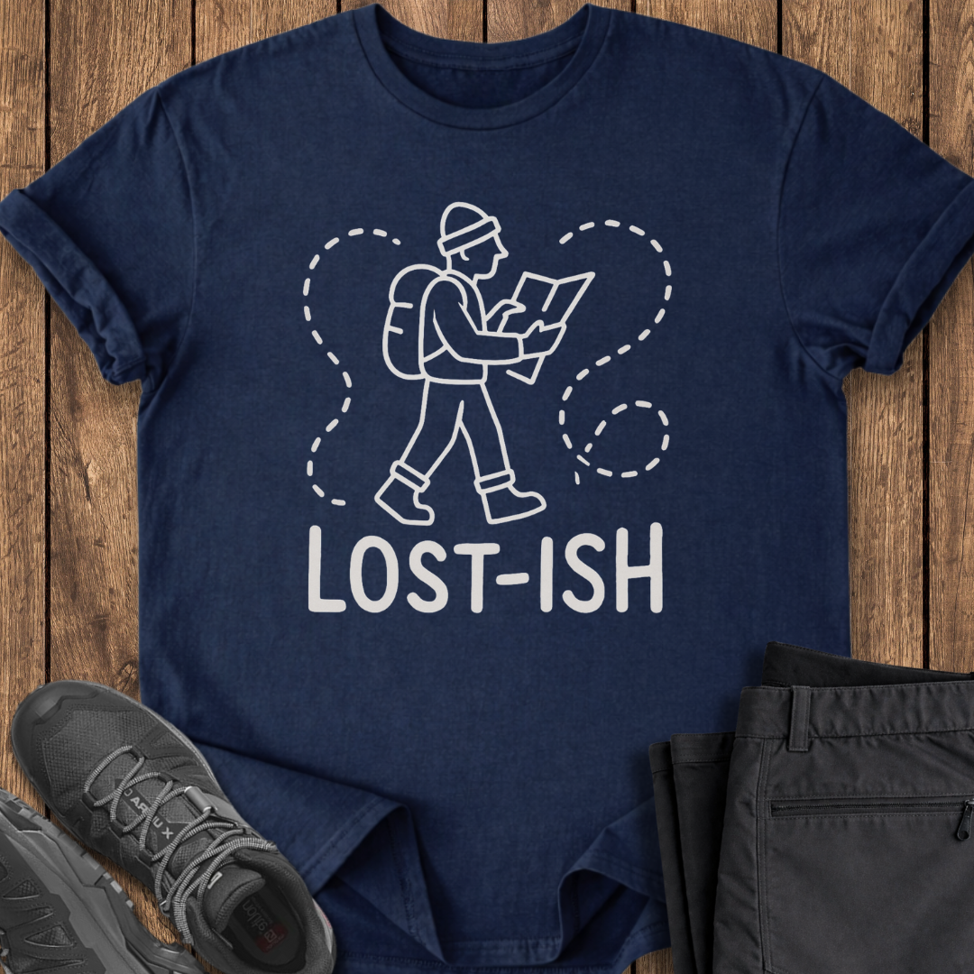Navy blue t-shirt with 'Lost-ish' graphic design on a wooden surface with shoes and pants.