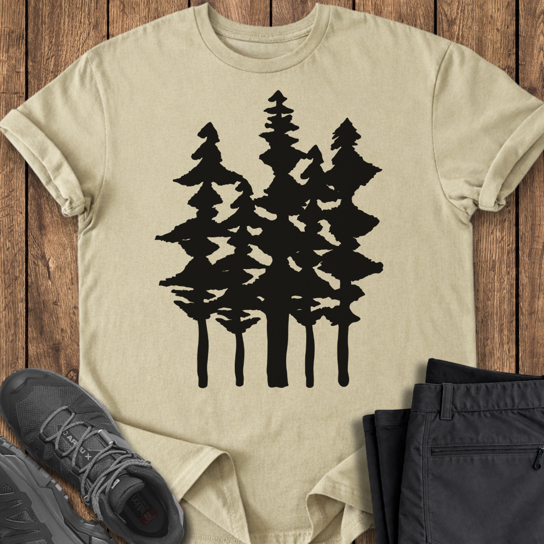 Beige t-shirt with black tree design on a wooden surface with shoes and pants.