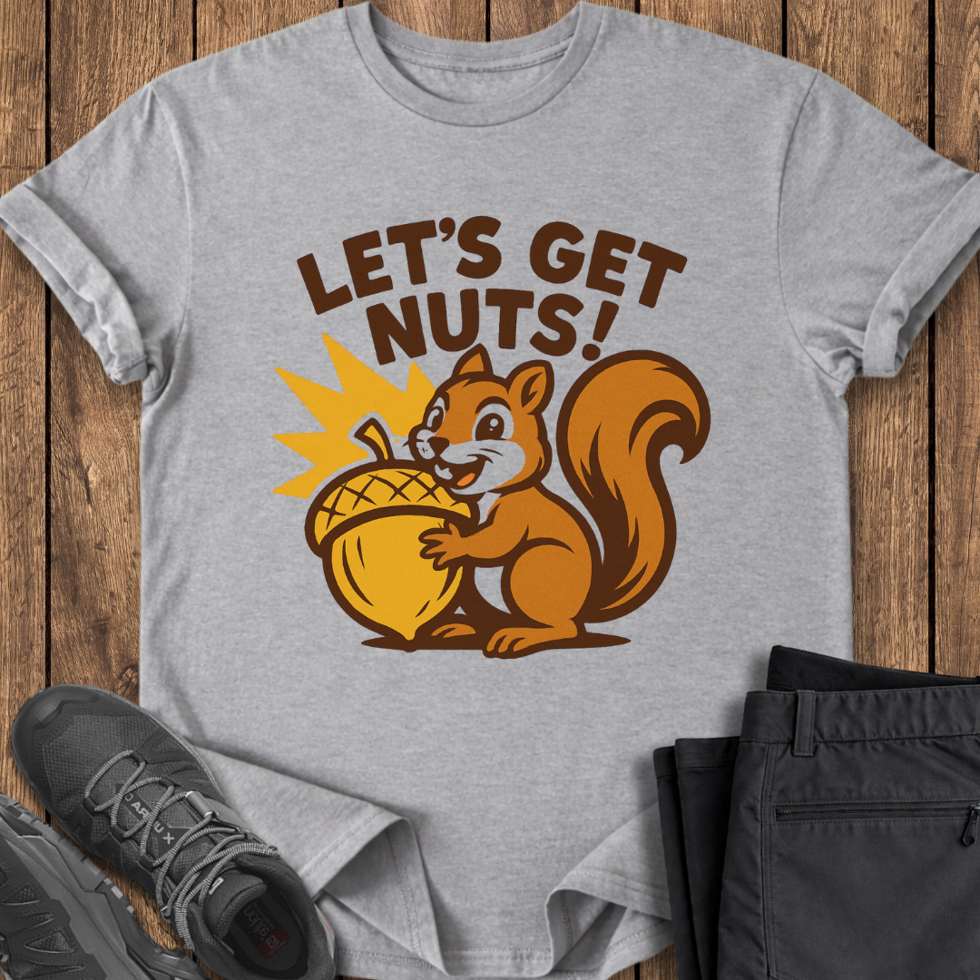 Gray t-shirt with a squirrel graphic and 'Let's Get Nuts!' text on a wooden surface with shoes and pants.