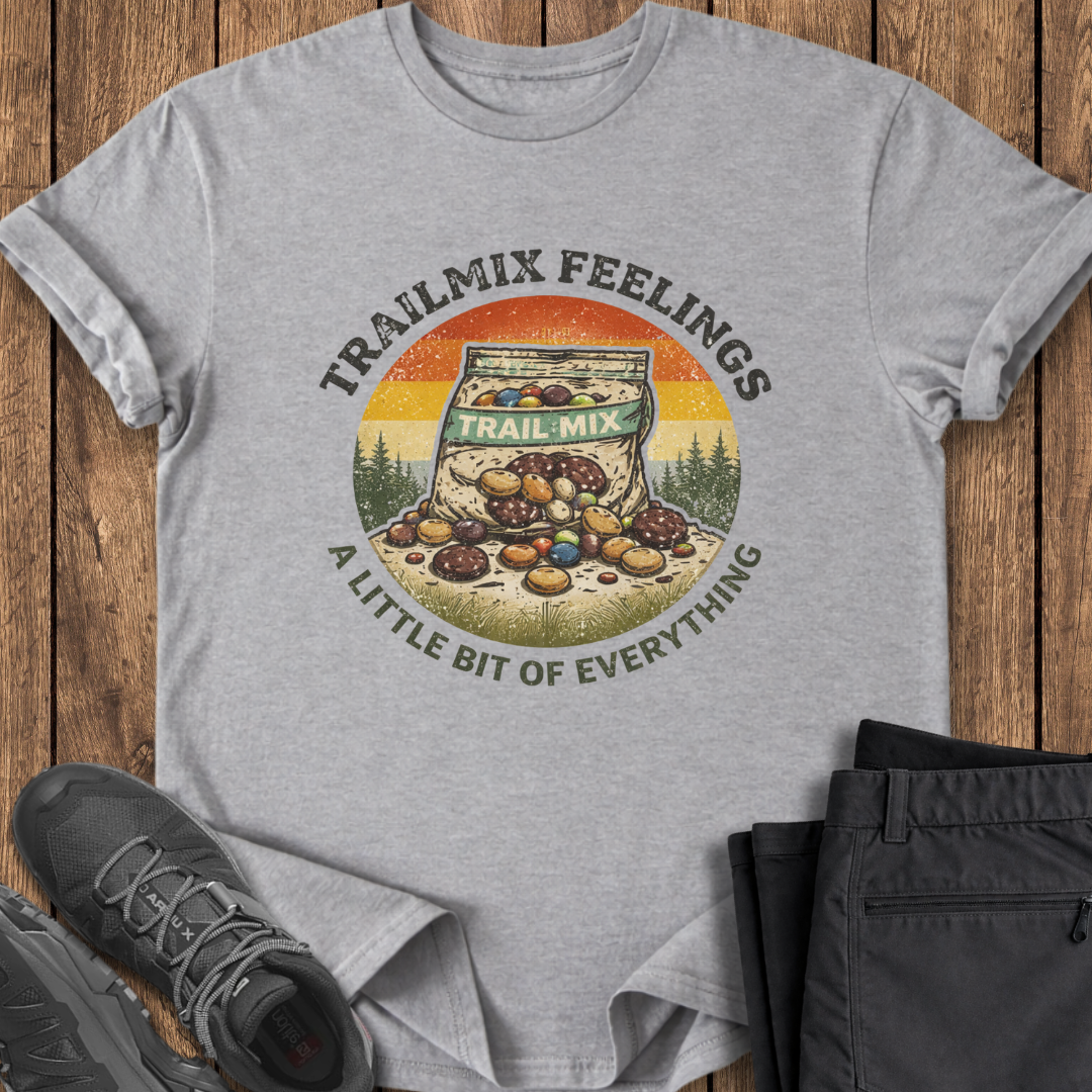 Gray t-shirt with 'Trailmix Feelings' graphic on a wooden surface with shoes and pants. funny hiking t shirts