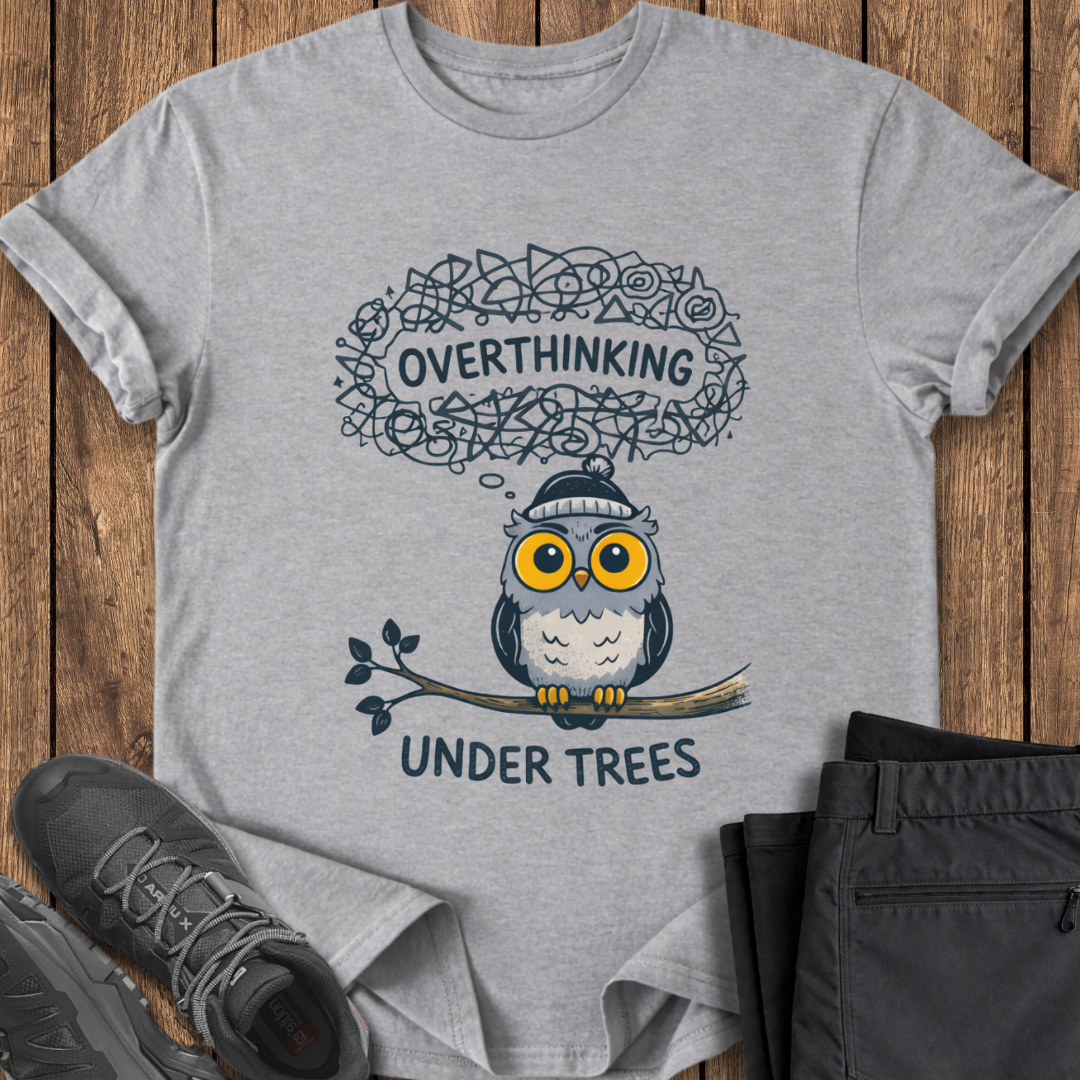 Gray t-shirt with an owl graphic and text on a wooden surface with shoes and pants. anxiety hiking t shirt