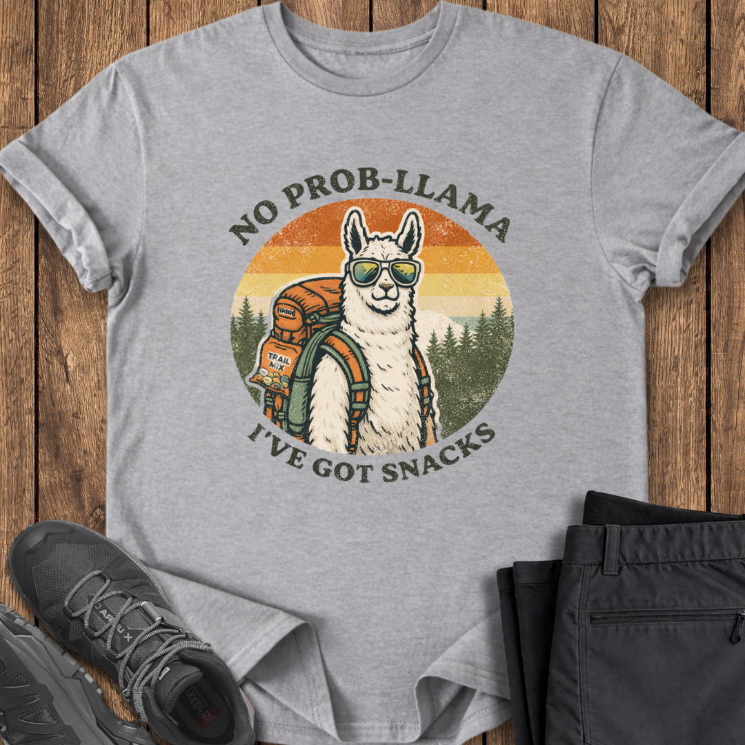 Gray t-shirt with a llama graphic and text on a wooden surface with shoes and pants. funny backpacking t shirt