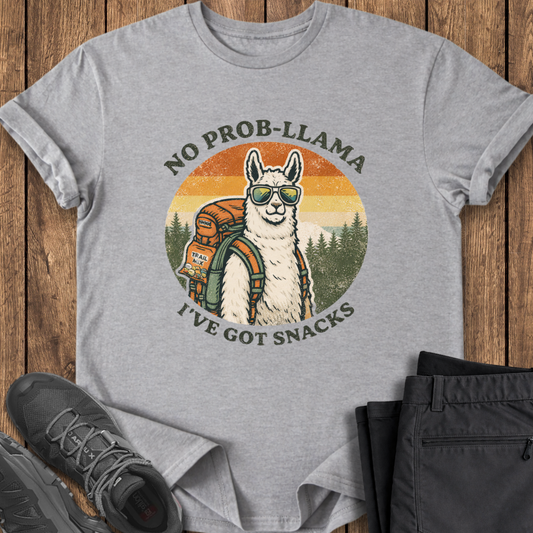 Gray t-shirt with a llama graphic and text on a wooden surface with shoes and pants. funny backpacking t shirt