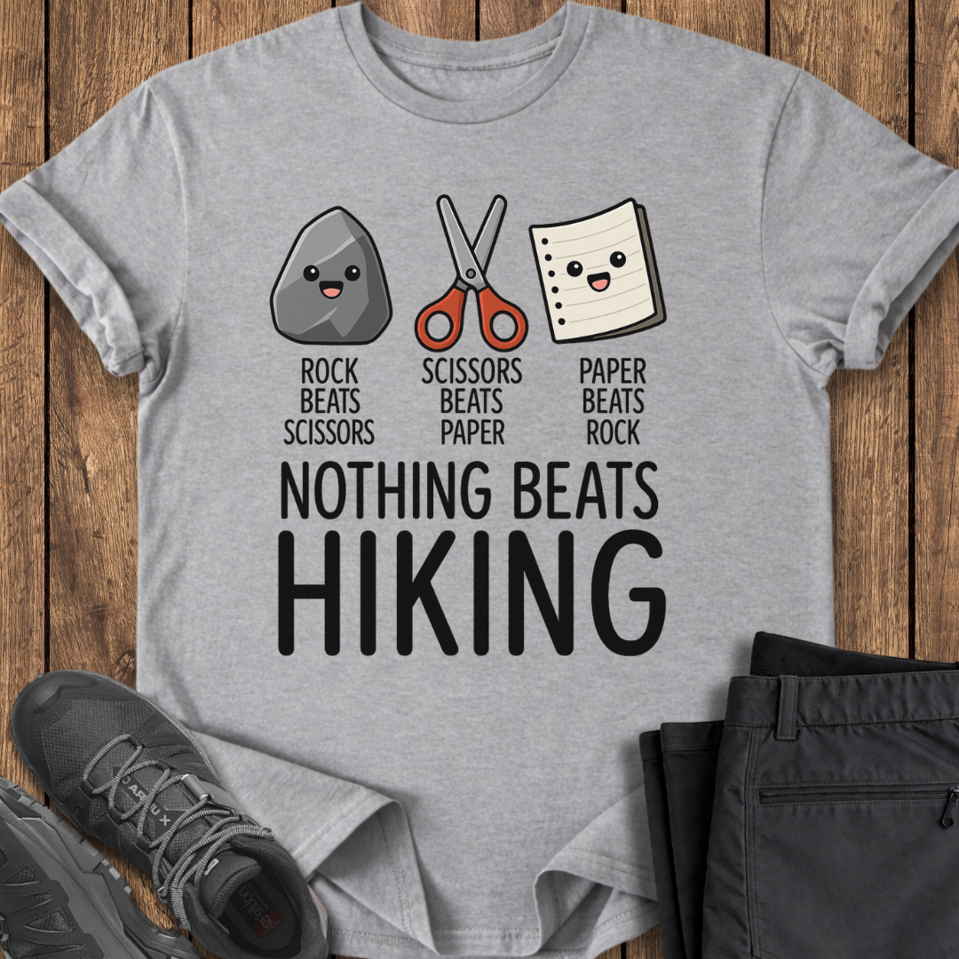 Gray t-shirt with rock, paper, scissors graphic and 'Nothing Beats Hiking' text on a wooden surface.
