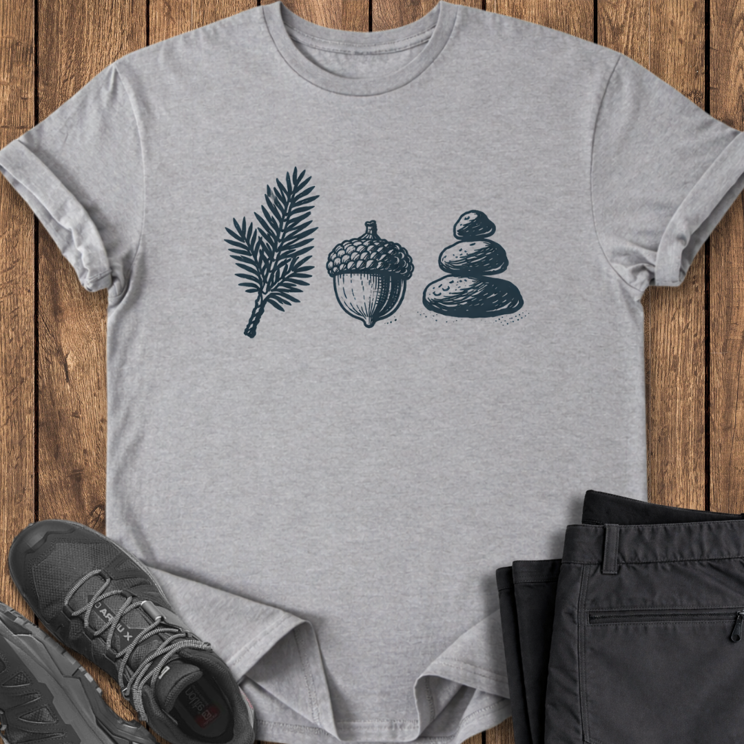 Gray t-shirt with nature-themed design on a wooden surface with shoes and pants. camping hiking t shirt
