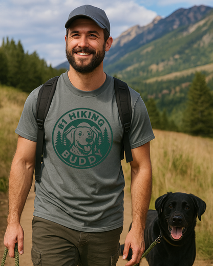 hiking wearing a '#1 Hiking Buddy' t-shirt with a dog graphic, standing outdoors with mountains and trees in the background.